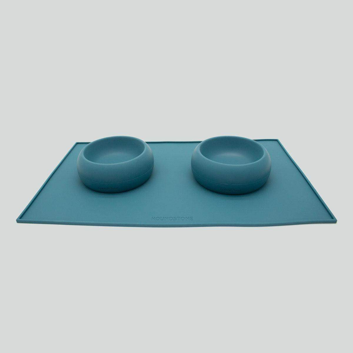 Houndstone silicone dog food mat in caribbean sea with two dog bowls on a white background
