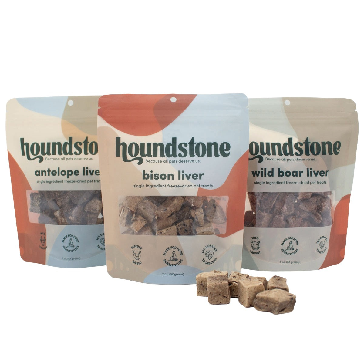 Three Houndstone freeze dried dog treats pouches arranged together on a white background, with several brown freeze dried dog treats placed in front. The pouches are labeled antelope liver, bison liver, and wild boar liver.