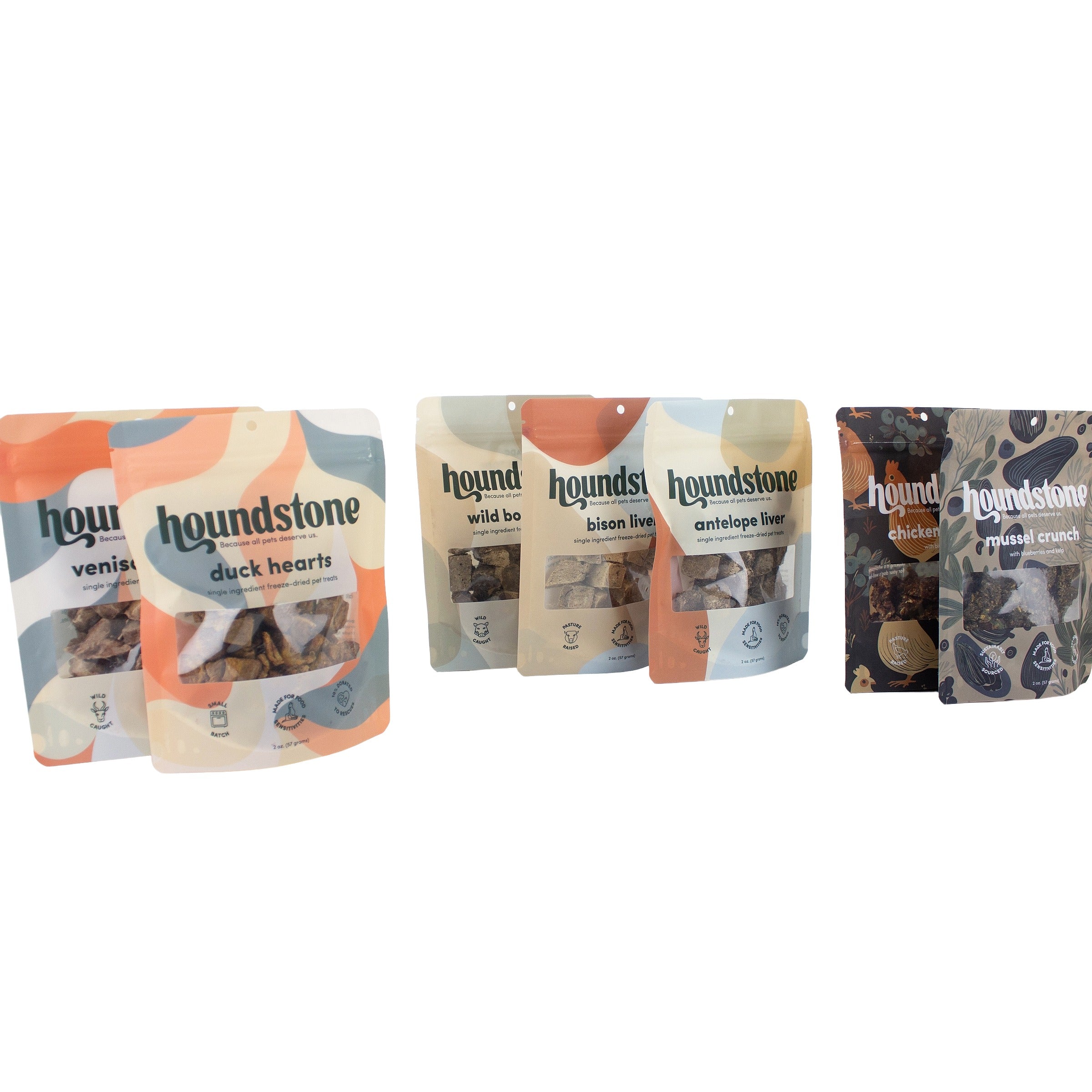 Seven Houndstone dog treat pouches arranged in a row on a plain white background, including venison, duck hearts, wild boar, bison liver, antelope liver dog treats, chicken, and mussel dog treats.