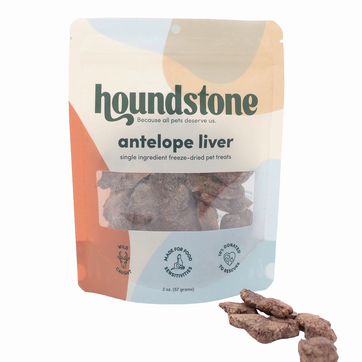A stand-up pouch of Houndstone Antelope Liver freeze dried dog treats with several dog treats placed in front on a white background.