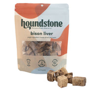 A 2 oz bag of Houndstone Bison Liver freeze dried dog treats, shown with several brown cube-shaped dog treats placed in front on a white background.