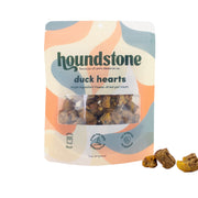 A package of Houndstone Duck Hearts single-ingredient freeze-dried dog treats, shown on a white background with three dog treats placed in front of the bag.
