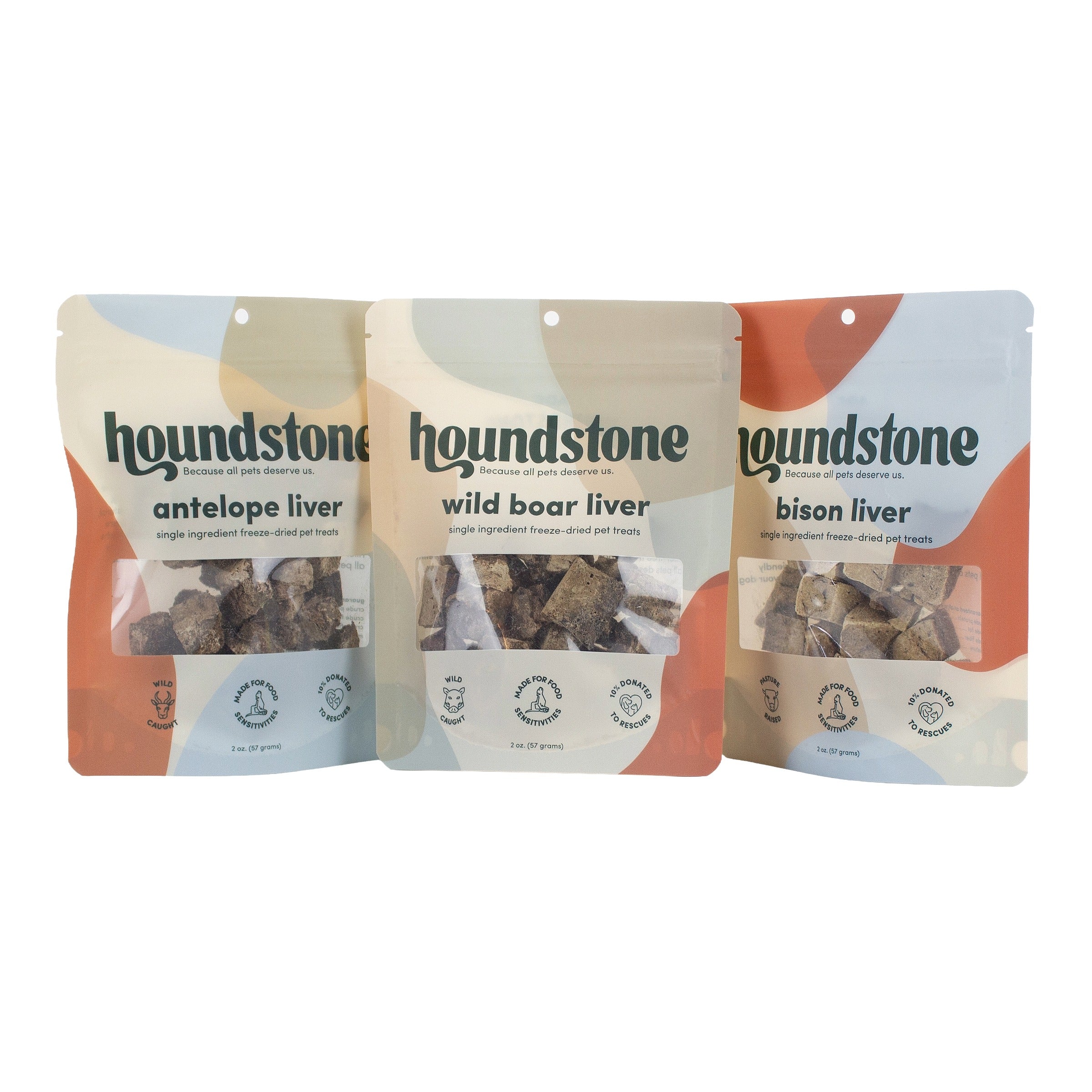 Three stand-up pouches of Houndstone freeze dried dog treats arranged side by side on a white background. The packages are labeled 'antelope liver,' 'wild boar liver,' and 'bison liver,' with a clear window showing the dark freeze dried dog treats inside.